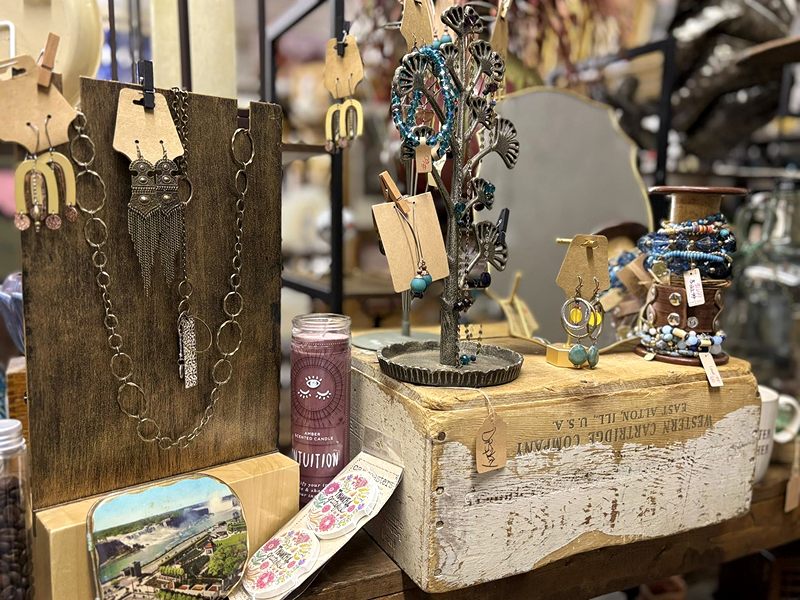 Necklaces, earrings and bracelets on wooden jewelry displays and an old crate