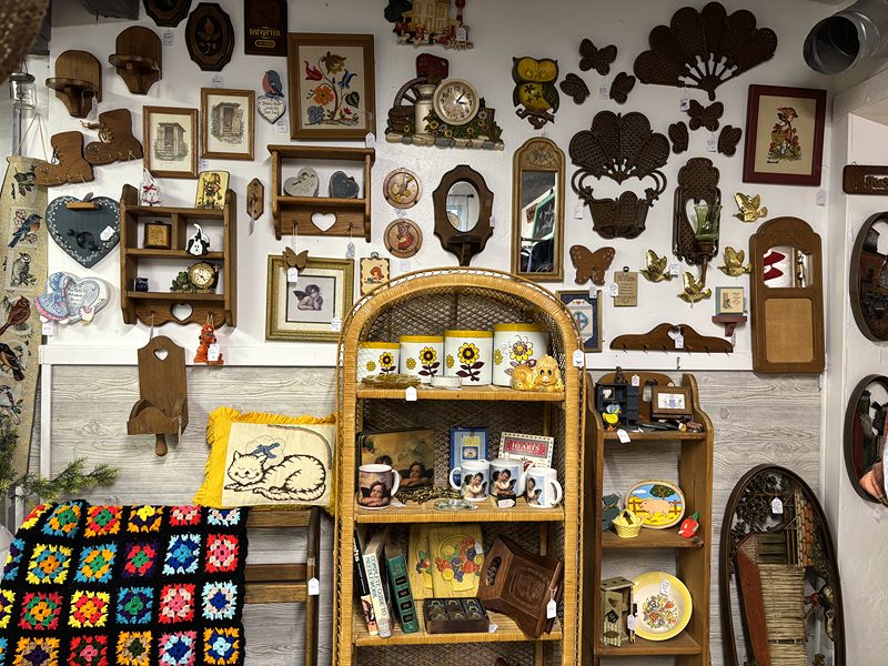 Wall hangings, a wicker shelf and a crocheted granny-square blanket