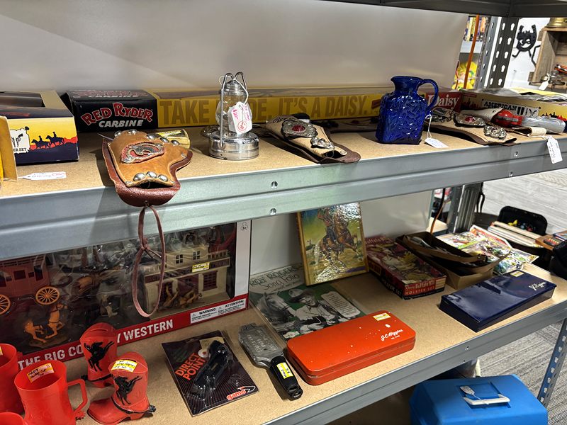 Metal shelves of Western-themed toys, tins and boxed collectibles