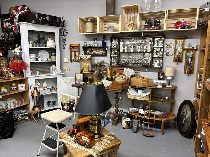 Wooden crates on the wall, white shelves of dishes, a stepstool and a table lamp
