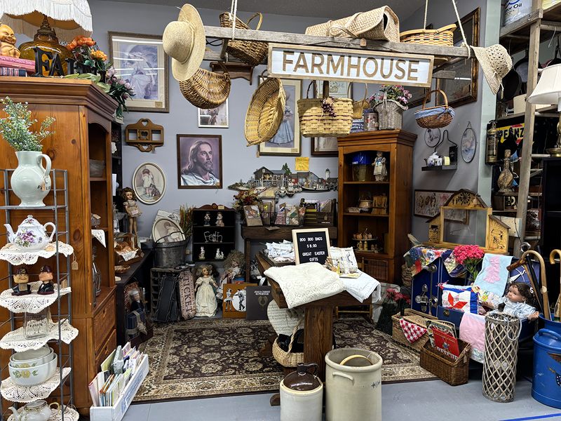 A farmhouse-themed room with baskets, a Farmhouse sign, teapots and a rug